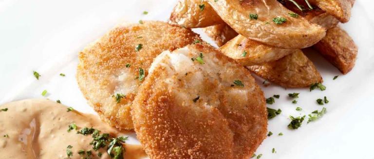 Breaded cod rolls with fried potato wedges